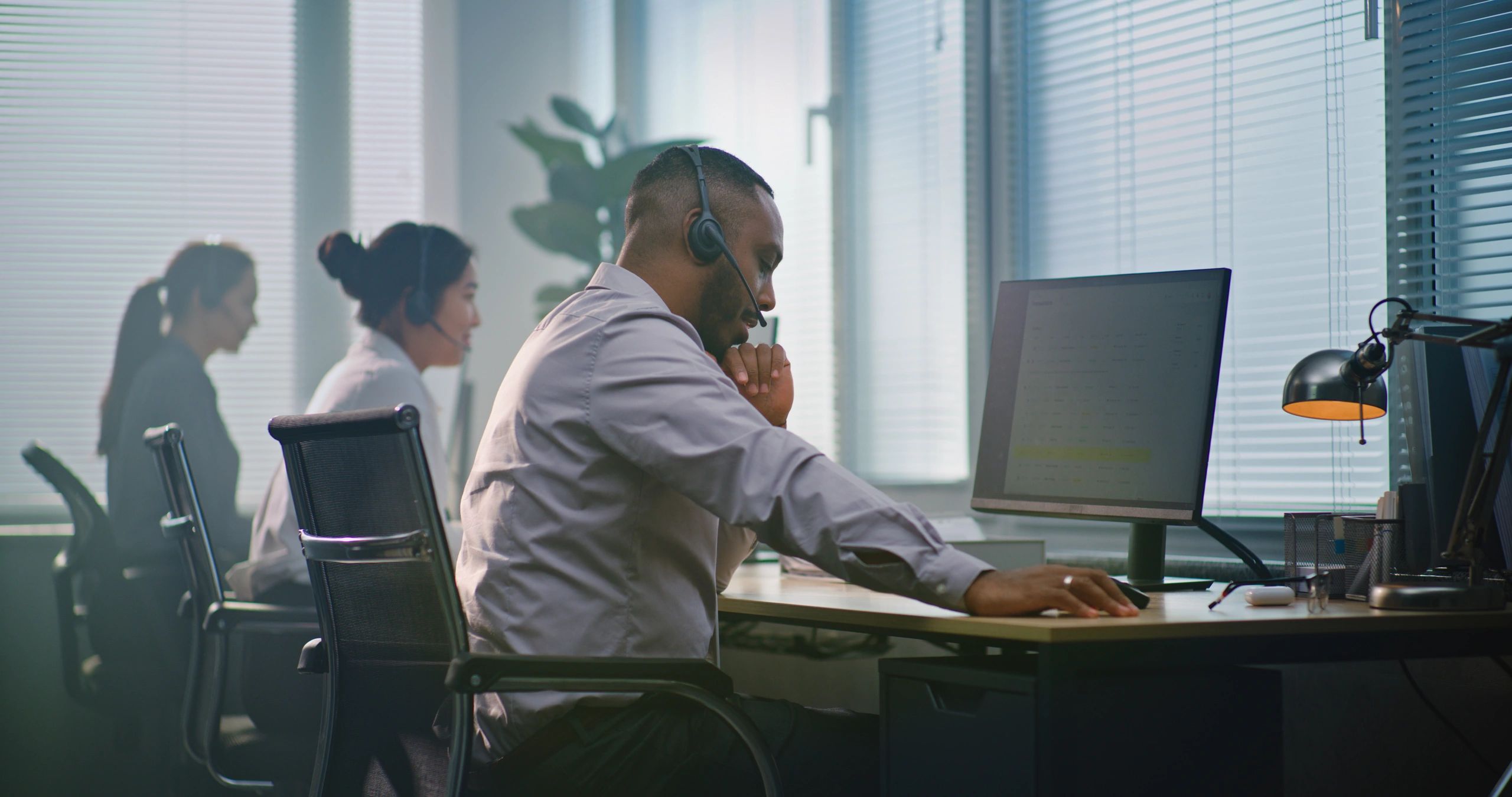 Technical support specialist assisting clients from a modern office